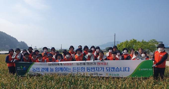 남해화학 임직원 50여명이 13일 전남 여수시 돌산읍 소재 마늘 농가를 방문해 마늘수확 일손돕기를 실시한 후 기념촬영을 하고 있다.