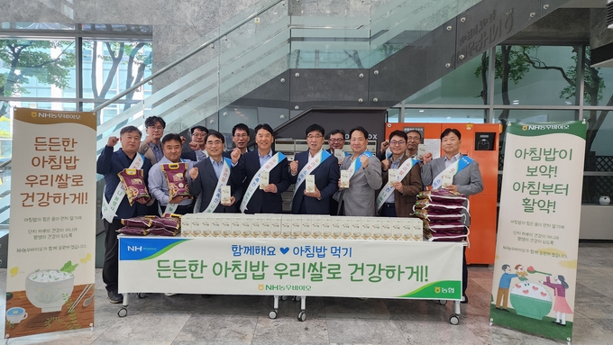 양현구 대표이사(앞줄 왼쪽 4번째 ) 등 NH농우바이오 임직원들이 이달 12일 경기도 광교 비즈니스 센터 인근에서 ‘범국민 아침밥 먹기 운동’ 일환으로 쌀 소비 촉진 캠페인 후 기념촬영을 하고 있다.
