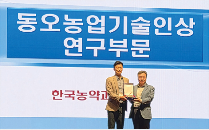 경농 최재명 마케팅부문 상무(오른쪽)가 동오 농업과학기술인상 연구부문 우수연구자로 선정된 충남대 성건묵 회원(왼쪽)에 대한 시상을 마친 후 함께 포즈를 취하고 있다.